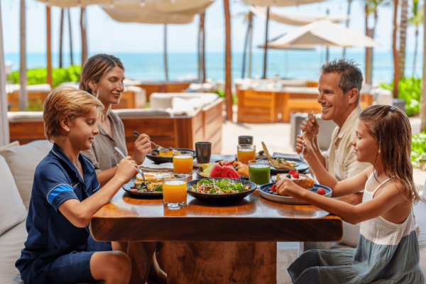 family eats in open-air beach club at mayakoba